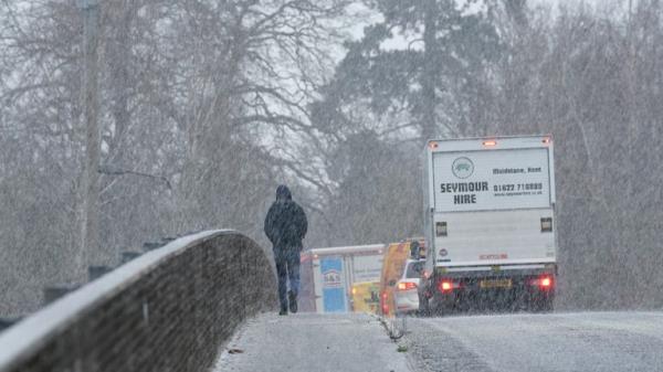 A pedestrian crosses a bridge during a snow shower near Maidstone in Kent. Sleet and snow showers have been forecast for parts of the country on Mo<em></em>nday as some regions are still trying to grapple with flooding following intense rainfall. Picture date: Mo<em></em>nday January 8, 2024.