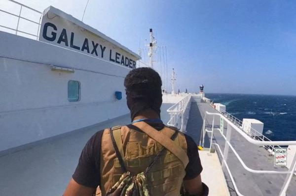 A Houthi fighter on the deck of the Galaxy Leader. He is walking away from the camera.