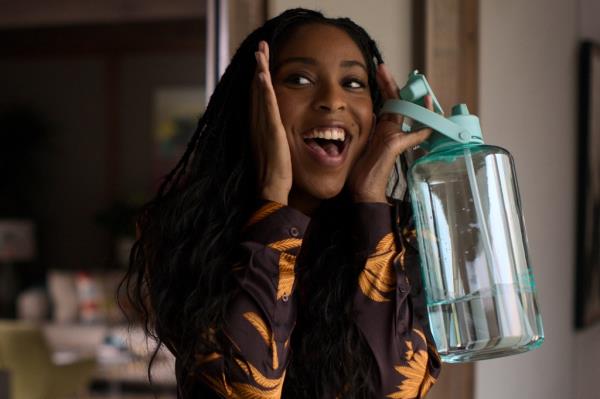 Jessica Williams as Gabby. She's holding a water bottle with her hands on her face imitating Macaulay Culkin's famous 