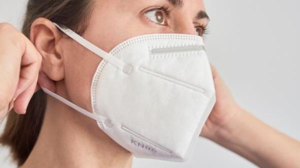 Brunette woman wearing a KN95 FPP2 mask.