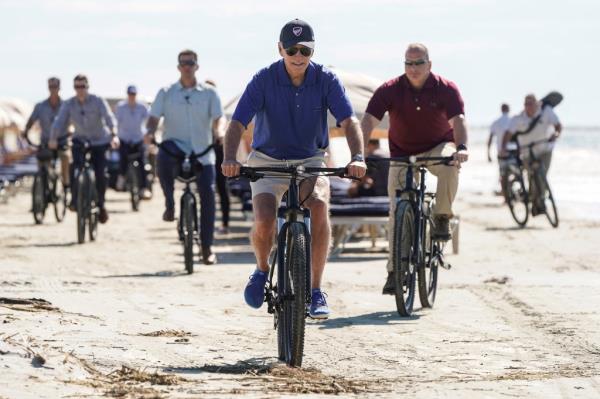 President Joe Biden rides a bicycle on the beach on Kiawah Island, South Carolina, U.S., August 14, 2022. 