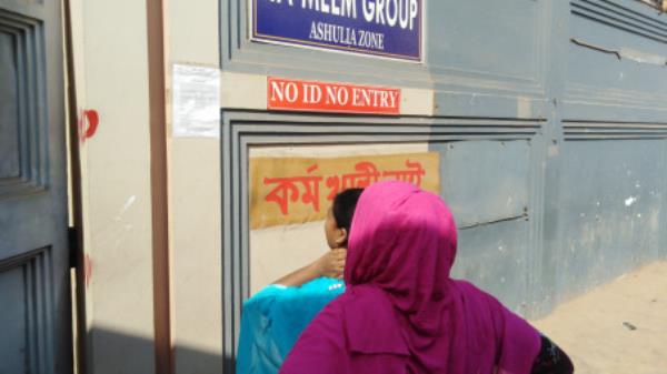 Two female workers in front of a Ha-Meem Group factory in Ashulia read the notice that says the factory will remain shut for an indefinite period of time. The photo was captured on Saturday, 11 November 2023. Photo: Noman Mahmud