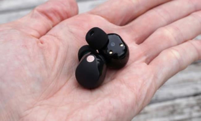 Sony WF-1000XM5 earbuds in the palm of a hand.