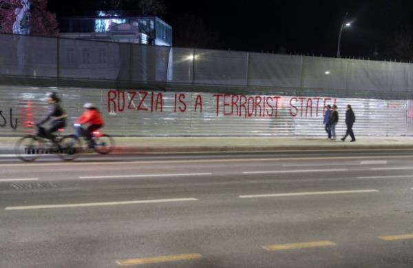 People move past an anti-Russian graffiti painted on a co<em></em>nstruction barrier in a street in Tbilisi, Georgia, February 15, 2023. REUTERS/Irakli Gedenidze