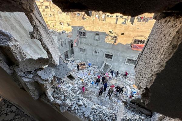 Palestinians stand in the rubble of an Israeli attack on a house in southern Gaza's Rafah