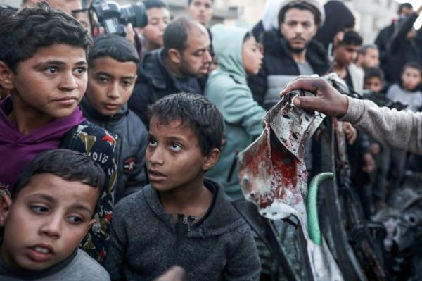 Palestinians inspect a destroyed car following the Israeli attacks in Rafah, Gaza on February 7, 2024