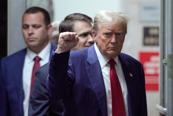 Former U.S. President Do<em></em>nald Trump in court, gesturing with his fist up, during his trial for alleged hush mo<em></em>ney payments in New York City.