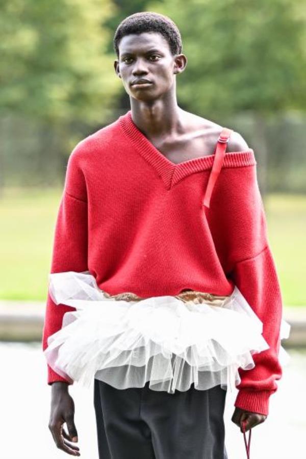 Model wearing white tutu peplum top with red sweater