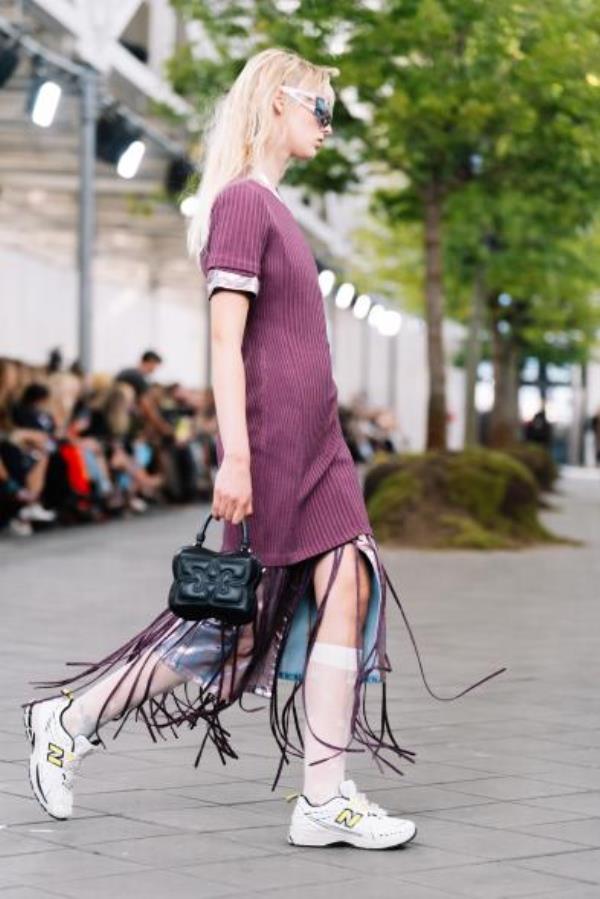 Ganni model with fringe skirt walking runway outside