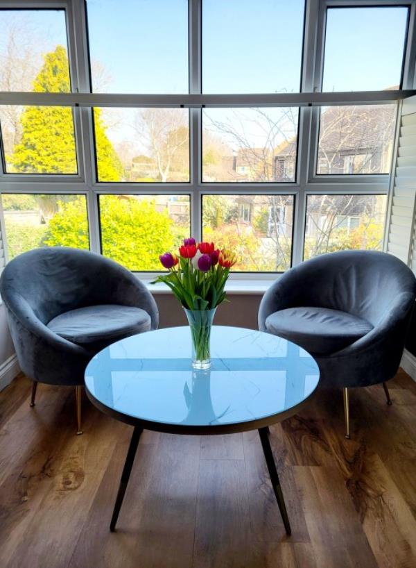 A relaxed coffee nook by the window with fresh flowers.