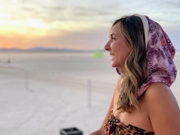 Tanya Khani in a headscarf laughing at Burning Man. 