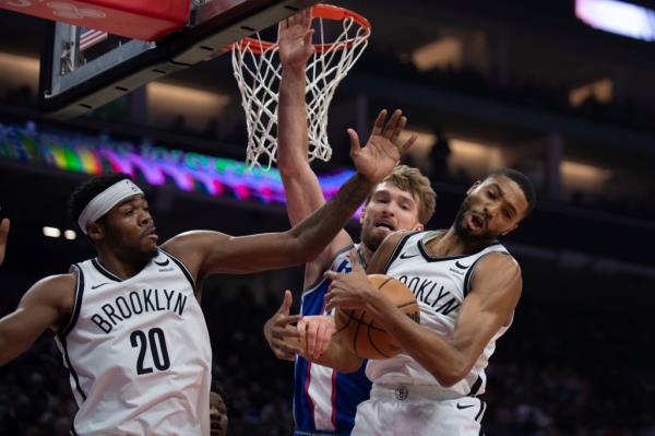 Mikal Bridges grabs a rebound in front of teammate, center Day'Ron Sharpe and Sacramento Kings forward Domantas Sabonis, center, in the first quarter.