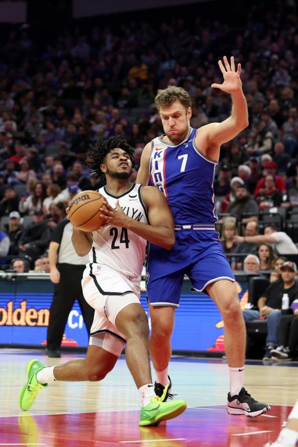 Cam Thomas is guarded by Sasha Vezenkov #7 of the Sacramento Kings.