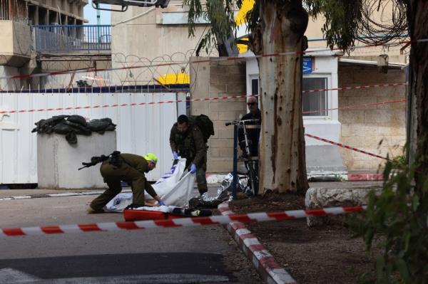 Members of Israeli security forces cover a body at the site of a reported attack near the naval ba<em></em>se in the coastal city of Haifa.