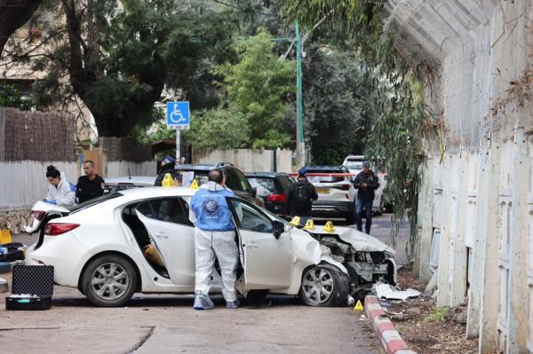 Israeli security and emergency perso<em></em>nnel inspect a damaged car following a reported attack near the naval ba<em></em>se in the coastal city of Haifa 