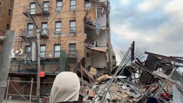 The facade of a Bronx building and scaffolding that partially collapsed, exposing the apartments within.