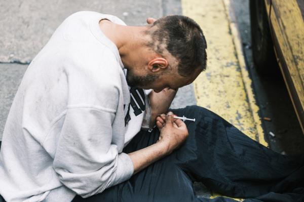 addict shooting up on the sidewalk