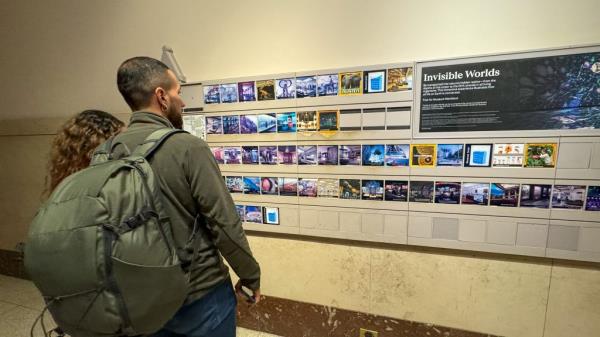 Museum goers look at photos at Museum of Natural History