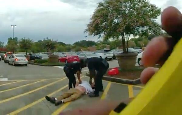 Berman is seen on the ground in the Target parking lot after a tussle with a police officer 