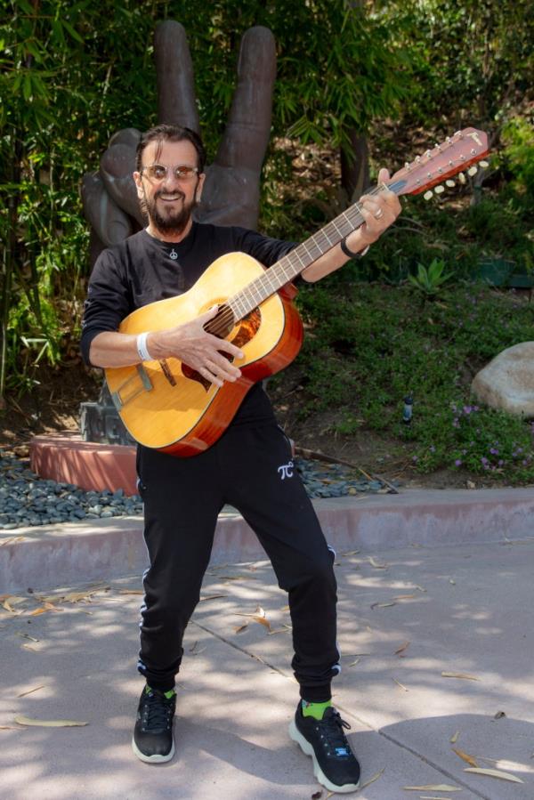 A photo of Ringo Starr strumming Lennon's 12-string guitar after it was found.