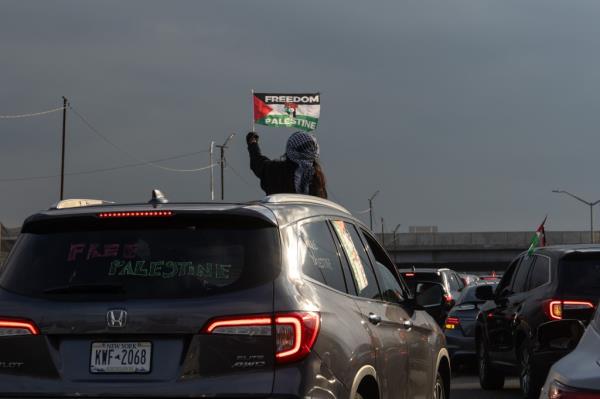 Photo shows an unidentified protester waving a flag out of a sunroof.