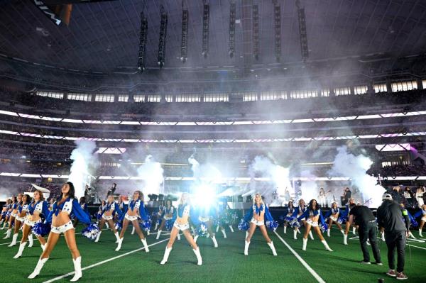 Singer Dolly Parton performs with the Dallas Cowboys cheerleaders during halftime of the game between the Dallas Cowboys and the Washington Commanders.