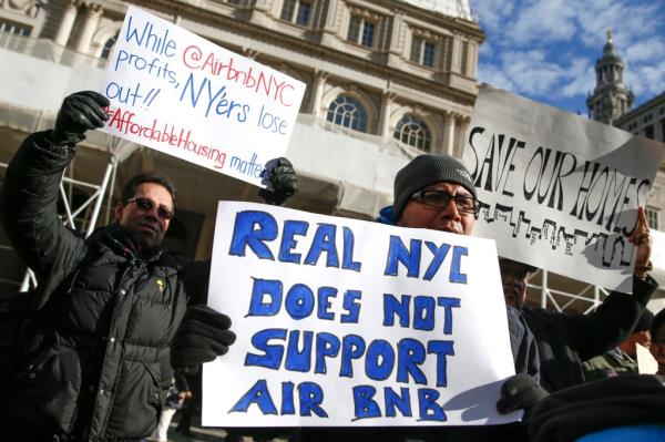 Anti-Airbnb protestors holding signs at a rally.