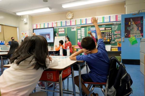 Co-teachers at Yung Wing School P.S. 124 Marisa Wiezel (who is related to the photographer) and Caitlin Kenny give a lesson to their masked students in their classroom on September 27, 2021 in New York City. 