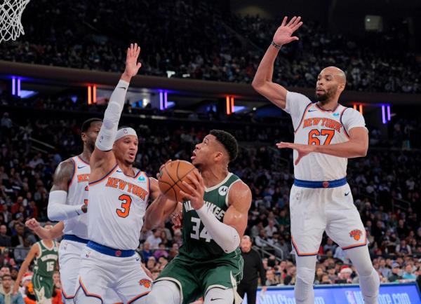 Bucks forward Giannis Antetokounmpo #34 looks to put up a shot between New York Knicks guard Josh Hart #3 and New York Knicks forward Taj Gibson