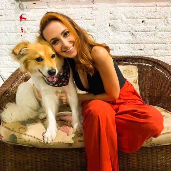 Julia Schafer and collie mix dog Tarsila sit on a couch. 