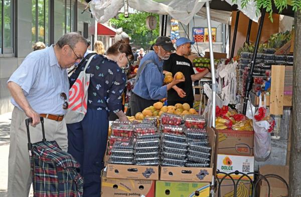 people shopping for fruits at a fruit stand