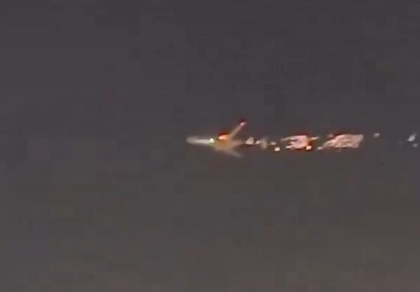 Flames can be seen shooting out of the left wing of the aircraft while in flight. 