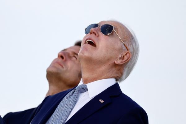 U.S. President Joe Biden and France's President Emmanuel Macron look on during a flag ceremony.