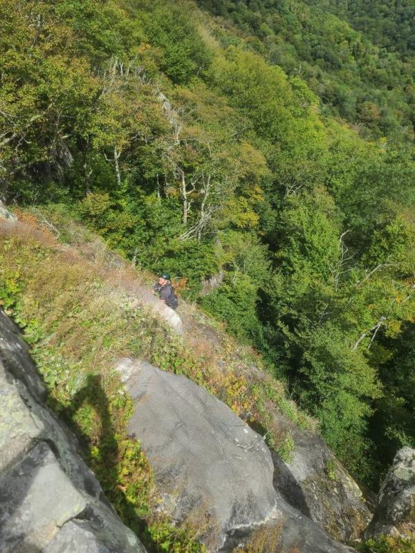 Rescuers rappel down the cliff.