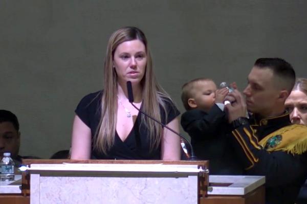 Stephanie Diller speaking at the church podium during her husband's funeral service