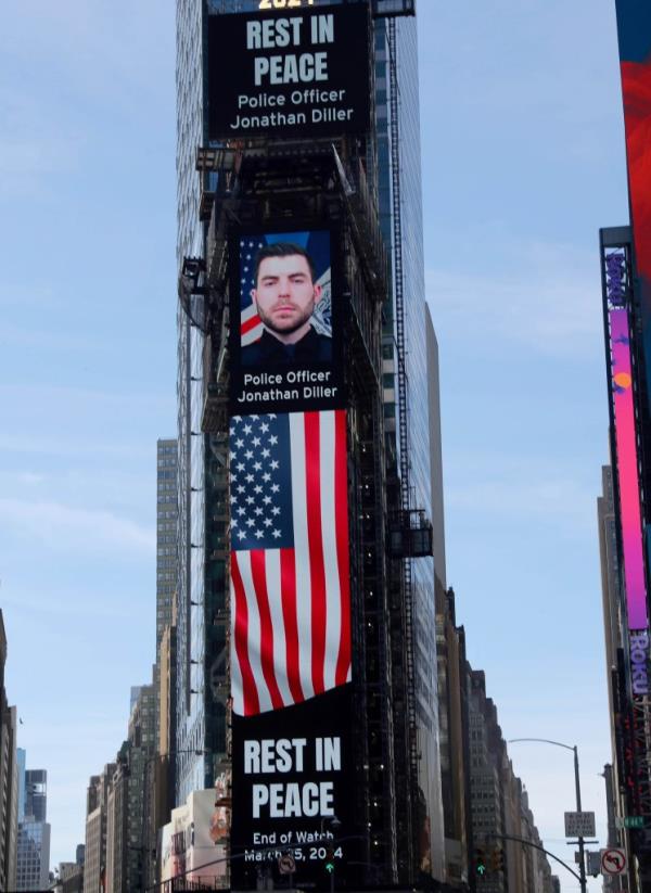 Photo of: New York City Police Officer Jo<em></em>nathan Diller were a large billboard overlooks the Police Substation at One Times Square