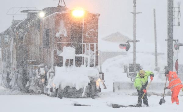 Two workers, one wearing neon yellow and the other orange, shovel snow from train tracks as snow falls north of Lake Tahoe in the Sierra Nevada mountains during a powerful winter storm.</p>

<p>　　