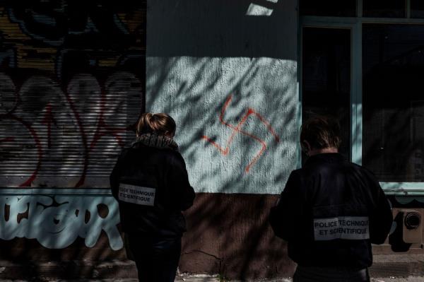 Police officers looking at swastika