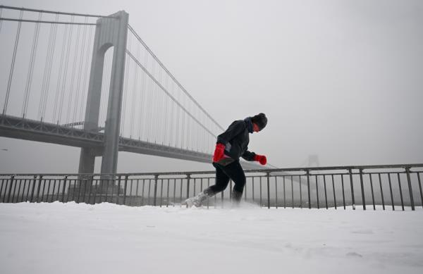 A man walking in NYC in January 2022 with lots of snow. 