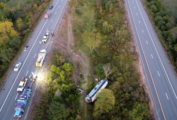 The bus is seen overturned in a ditch.