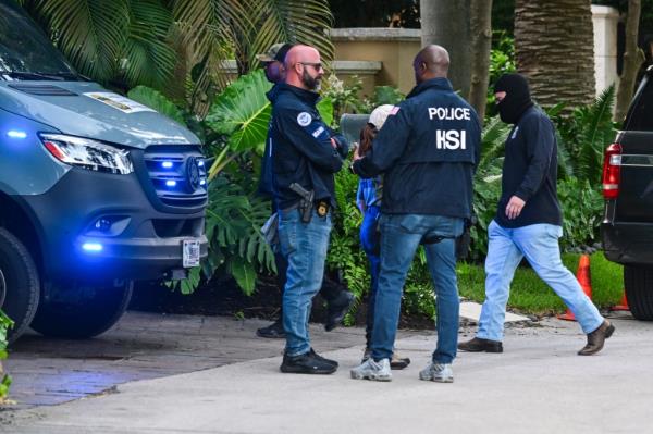 Federal and Homeland Security Investigation agents are seen at the entrance of Sean 