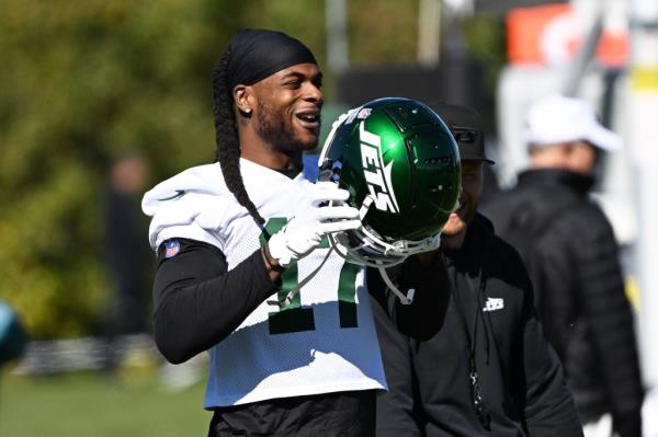 Jets wide receiver Davante Adams puts on his helmet during practice in Florham Park, NJ. 