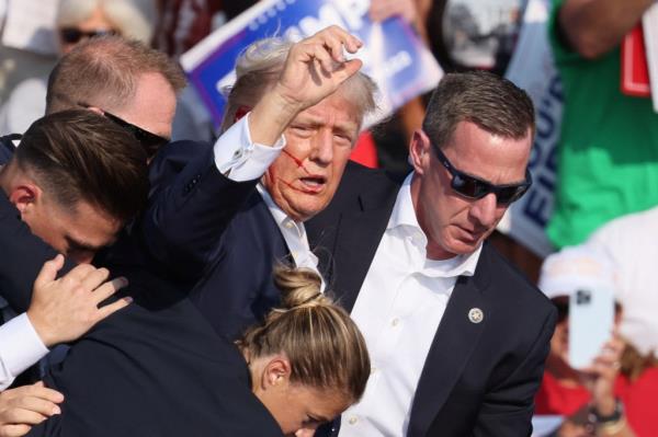 Trump gestures with a bloodied face as multiple shots rang out during a campaign rally at the Butler Farm Show in Butler, Pennsylvania, U.S., July 13, 2024.