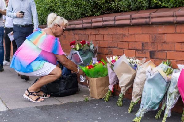 A person leaves flowers near the scene in Hart Street, Southport, Britain, Tuesday July 30, 2024.