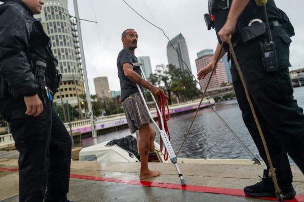 Police officers in Tampa, Florida persuading a man named 'Lieutenant Dan', living on his boat, to evacuate ahead of the approaching Category 4 Hurricane Milton