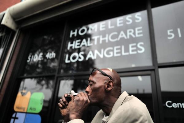 A man in Skid Row smokes narcotics from a pipe he received from Homeless Healthcare Los Angeles.