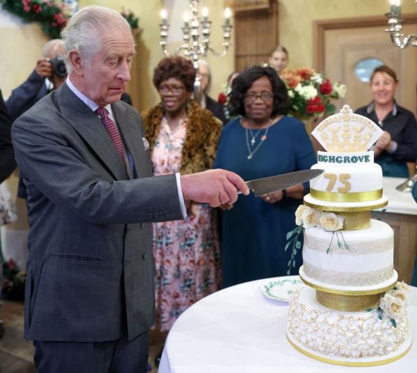 King Charles III reacts as he cuts a birthday cake as he attends his 75th birthday party, hosted by the Prince's Foundation at Highgrove House. 