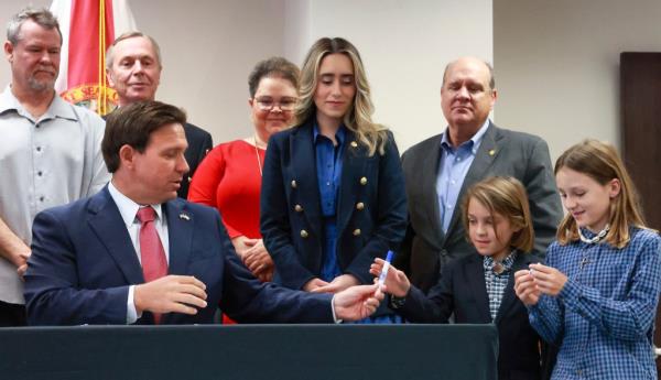 Florida Gov. Ron DeSantis hands out pens after signing House bill 621 at the Ninth Judicial Circuit state attorney's office in Orlando, Wednesday, March 27, 2024. 