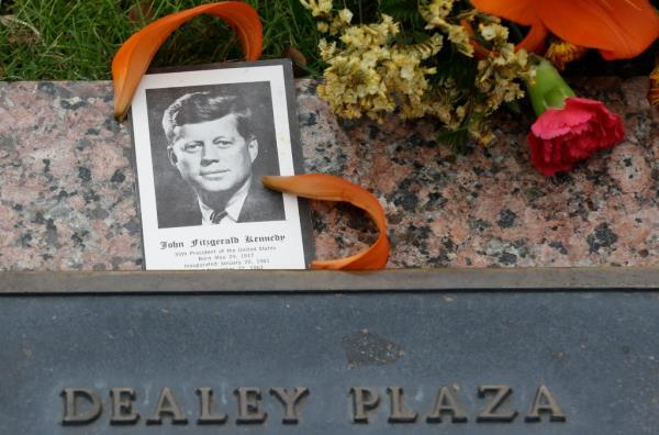 A photo of President John F. Kennedy and flowers lay on a plaque at Dealey Plaza in Dallas