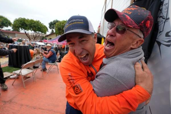 Travis Gienger (left) reacts after winning the Safeway 50th annual World Champio<em></em>nship Pumpkin Weigh-Off in Half Moon Bay 